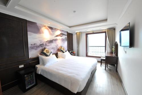ein Hotelzimmer mit einem großen weißen Bett und einem Fenster in der Unterkunft Delta Sapa Hotel in Sa Pa