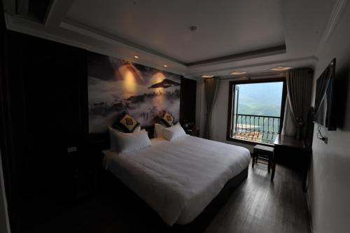 a hotel room with a bed and a large window at Delta Sapa Hotel - Old Quarter Center in Sa Pa