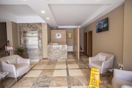 a lobby with two chairs and a stone wall at Otel Vona in Ordu