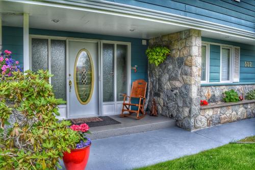 a front door of a house with a chair on the porch at Sunny Shuswap B&B in Chase