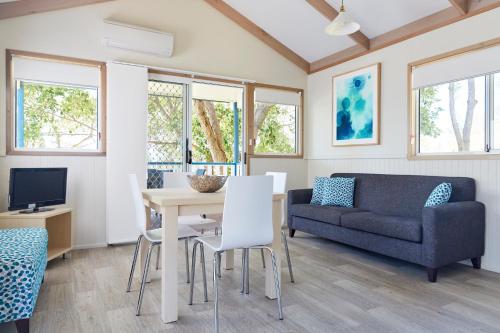 a living room with a table and a couch at NRMA Port Macquarie Breakwall Holiday Park in Port Macquarie