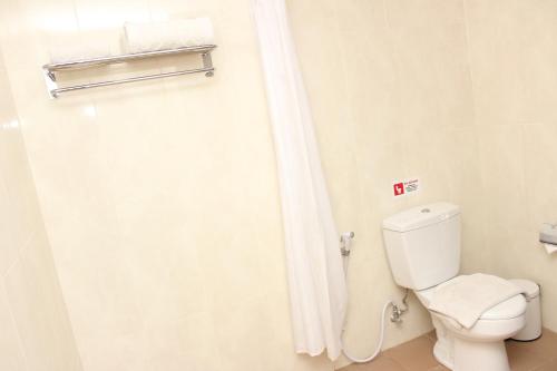 a bathroom with a toilet and a shower curtain at Naka Hotel Kupang in Kupang