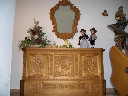 two dolls on top of a wooden dresser with a mirror at Gästehaus Burgi in Fügen