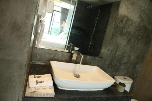 a bathroom with a sink and a mirror at Inthira Vangvieng in Vang Vieng