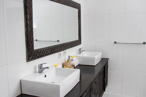 a bathroom with two sinks and a mirror at Villa Gardenia in Seminyak