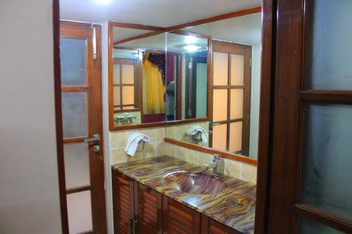 a bathroom with a sink and a large mirror at Classic Dineout in Gandhinagar