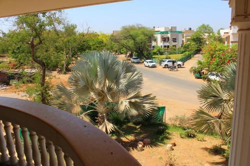 a balcony view of a street with a palm tree at Classic Dineout in Gandhinagar