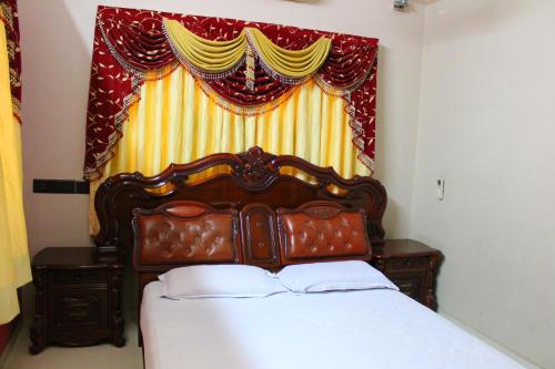 a bedroom with a bed and a window with a curtain at Classic Dineout in Gandhinagar