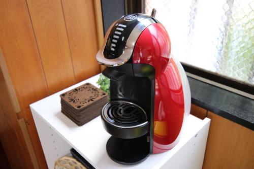 a red and black appliance sitting on a shelf at Holiday Homes TSUBOYA 2nd in Naha
