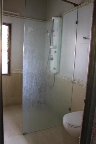 a shower stall in a bathroom with a toilet at Classic Dineout in Gandhinagar