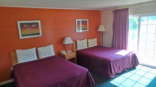 a hotel room with two beds and a window at Relax Inn Yreka in Yreka