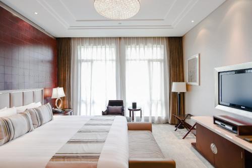 a hotel room with a large bed and a flat screen tv at Xijiao State Guest Hotel in Shanghai
