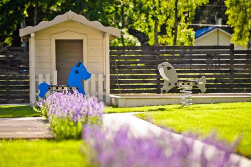 a toy dog house in a yard with purple flowers at Domki Na Brackiej in Pobierowo