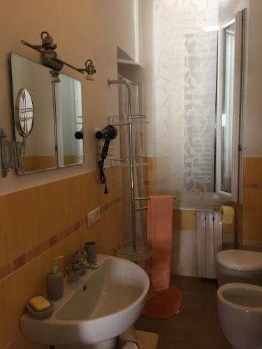 y baño con lavabo, ducha y aseo. en Apartment Salivoli, en Piombino