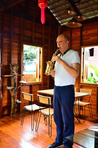 a man standing in a room playing a saxophone at The Choice Hotel - Adults Only in Bangkok