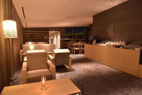 a living room with a table and chairs and a bar at The Meibia Miyazaki in Miyazaki