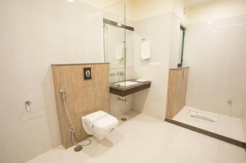 
a white toilet sitting next to a white sink at Hotel Fortune Plaza in Ajmer
