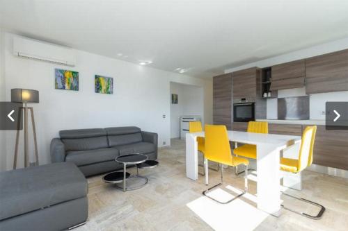 un salon avec une table et des chaises jaunes dans l'établissement Modern Croisette & Palm Beach, à Cannes