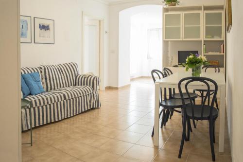 salon ze stołem, krzesłami i kanapą w obiekcie The Green Carpet w mieście La Spezia