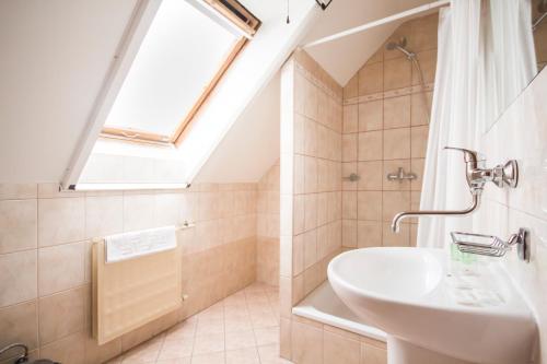 a bathroom with a sink and a skylight at Film Hotel in Bratislava