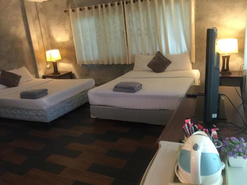a hotel room with two beds and a sink at Crescent Bay Resort in Ko Samed