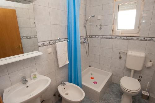 a bathroom with a white toilet and a sink at Apartments Lucia in Podstrana