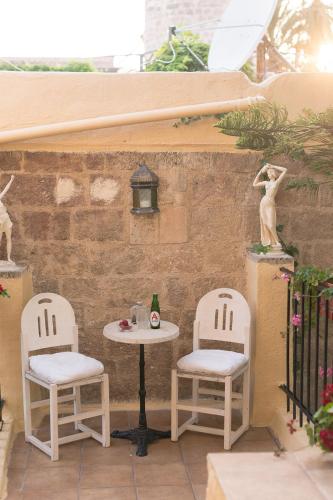 a patio with two chairs and a table and a small table at Kristina´s rooms in Rhodes Town