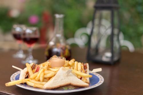 a plate of food with a sandwich and french fries at Kristina´s rooms in Rhodes Town