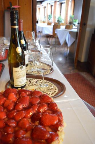 a bottle of wine and a cake on a table with wine glasses at Alemannenhof Hotel Engel in Rickenbach