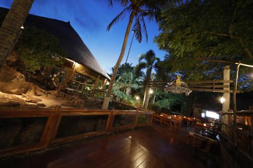 a resort with a wooden deck at night at Mara River Safari Lodge Bali in Keramas