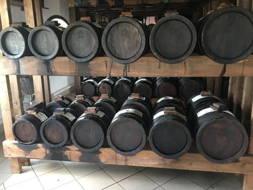 a bunch of wine barrels on a wooden shelf at La Corte D'Emilio B&B in Vignola