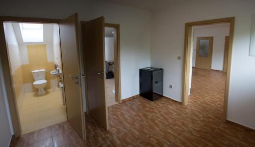a bathroom with two doors and a toilet in a room at Ubytovani U Ruzenky in Velké Bílovice