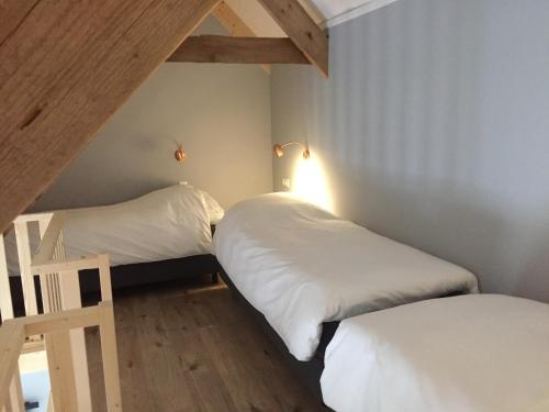 two beds in a small room with white sheets at B&B Erve ten Dam in Ambt Delden