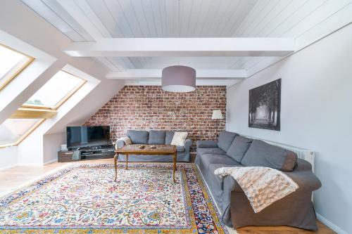 a living room with a couch and a brick wall at Ferienwohnungen am Markt in Bad Grund