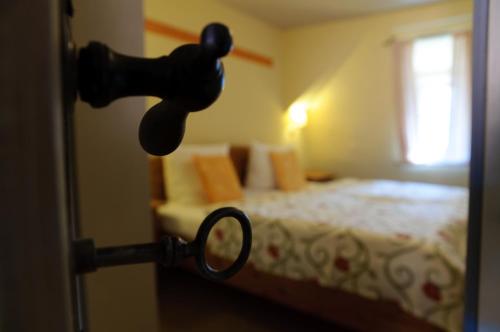 a door handle to a bedroom with a bed at Hotel am Hoken in Quedlinburg