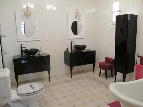 a bathroom with two sinks and two mirrors at L'Oustau de Bigatié in Lambesc