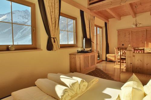 een woonkamer met een bank en een aantal ramen bij Rimlhof by A CASA in Längenfeld