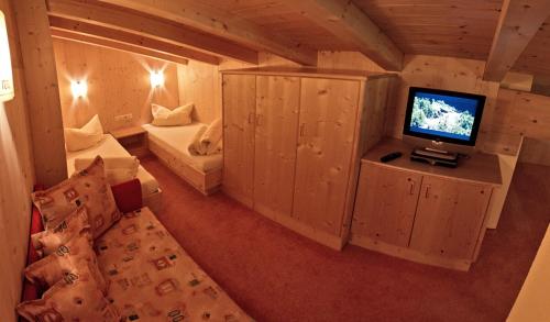a room with a tv and a couch in a room at Rimlhof by A CASA in Längenfeld