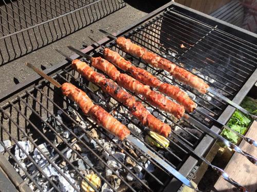 a group of sausages cooking on a grill at Villa Kaiser in Lviv