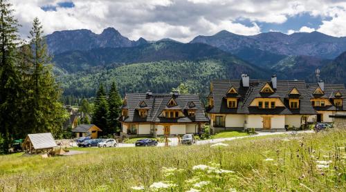 a group of houses with mountains in the background at Rent like home - Sywarne II in Kościelisko