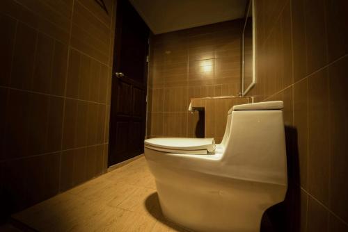 a bathroom with a white toilet in a room at Khuang Chang Kam in Nan