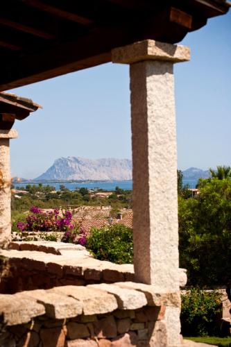 a stone wall with a view of the mountains at Miriacheddu in San Teodoro