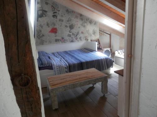 - une chambre avec un lit et un banc dans l'établissement Buhardilla Casco Historico, à Burgos