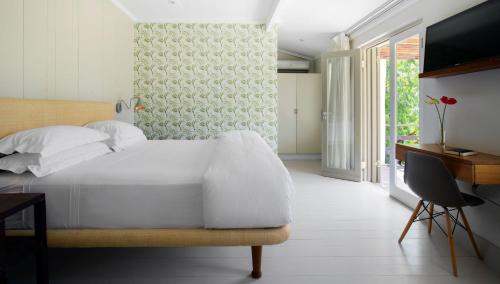Dormitorio con cama, escritorio y TV en Cape Standard Guest House en Ciudad del Cabo