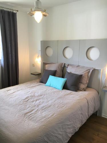 ヴィムルーにあるLe Wim'Heureux Terrasseのベッドルーム1室(大型ベッド1台、青い枕付)