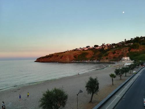 a beach with houses on a hill next to the ocean at Noemi Holiday House in Agnone Bagni