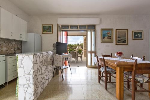 a kitchen with a table and a dining room at Riva del Conte by BarbarHouse in Punta Prosciutto