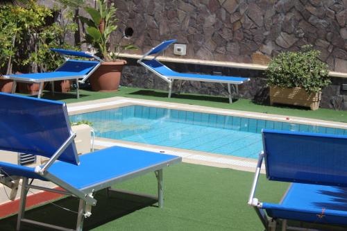 un gruppo di sedie e una piscina di Hotel La Filadelfia a Città di Lipari