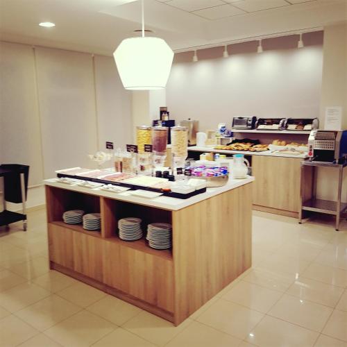 a restaurant with a counter with plates on it at Hotel Cristina in Los Alcázares