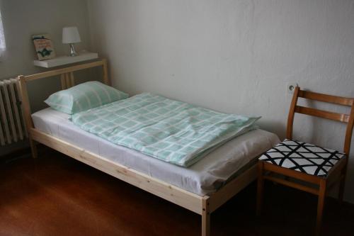 Mcely的住宿－Vejminek U Drahušky Mcely，一张小床,位于带椅子的房间里